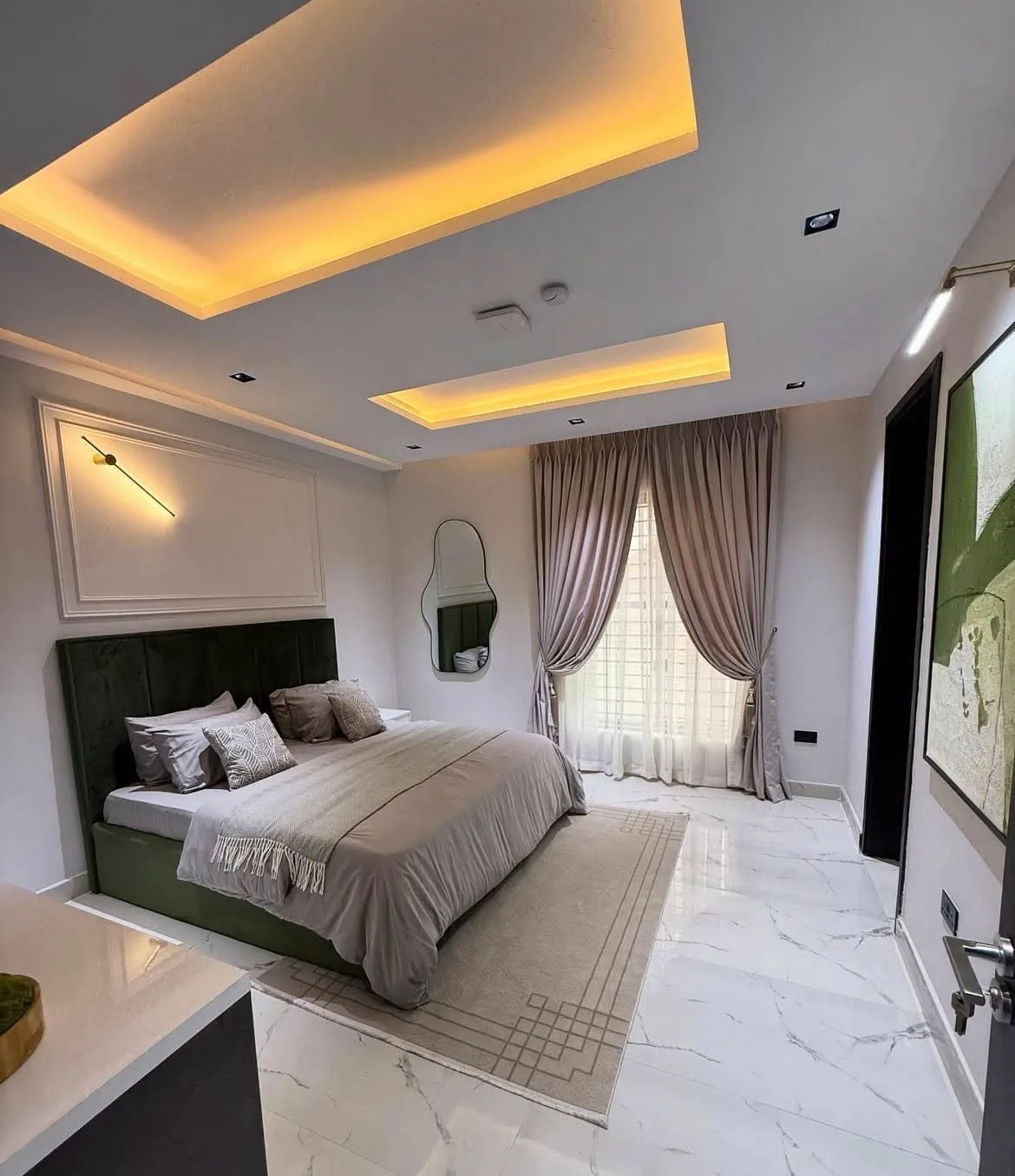 Primary bedroom with olive green bed and marble flooring