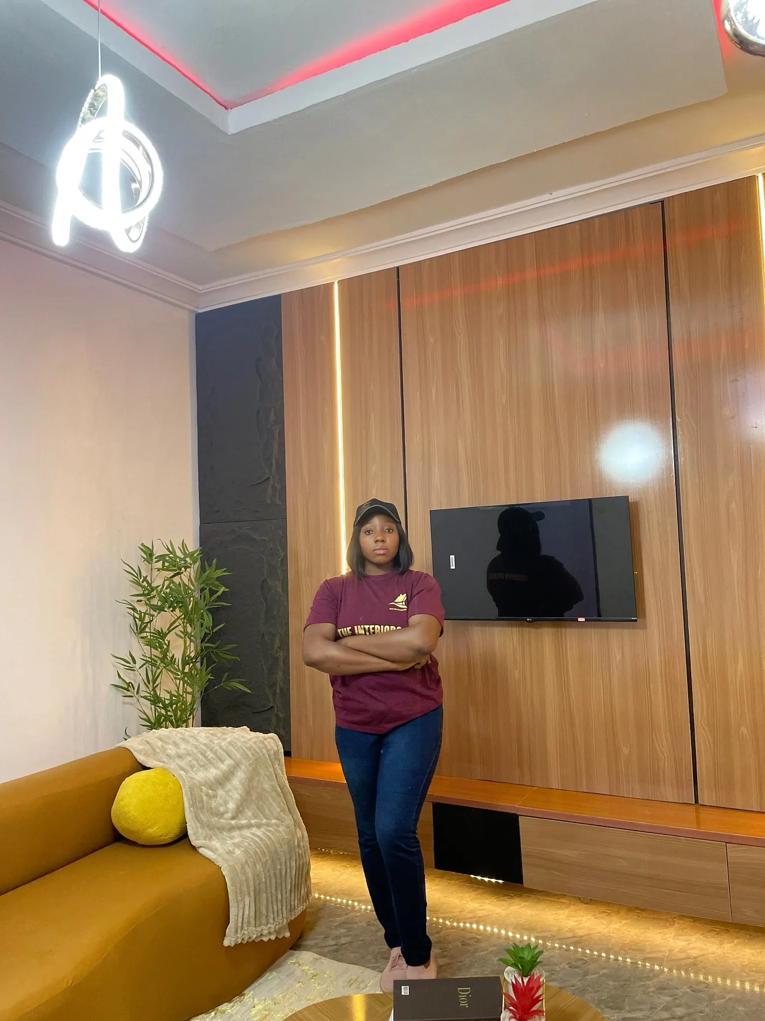 Designer standing in front of the textured dark slate and wood media wall